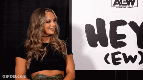 Woman Standing In Front Of Hey Crew Sign GIF