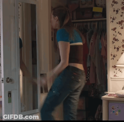 Woman Standing In Front Of Mirror In Bedroom GIF