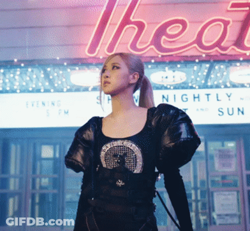 Woman Standing In Front Of Nightly And Sun Sign GIF
