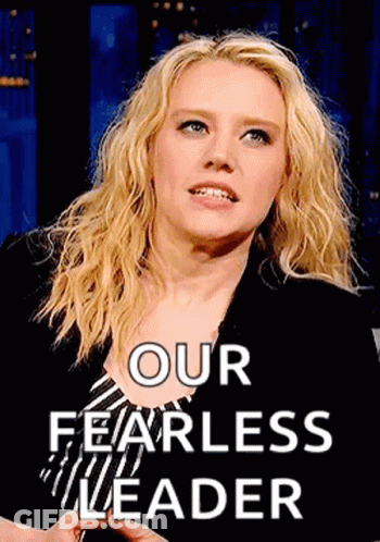 Woman Standing In Front Of Our Fearless Leader Sign GIF