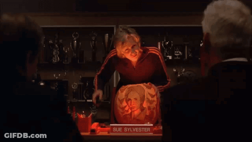 Woman Standing In Front Of Pumpkin With Sue Sylvester Picture GIF