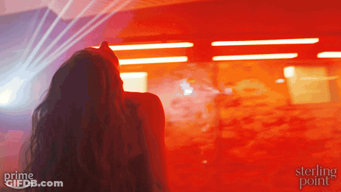 Woman Standing In Front Of Red Wall With Sterling Point GIF