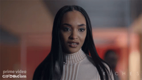 Woman Standing In Front Of Riches Sign GIF