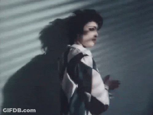Woman Standing In Front Of Shadowed Wall GIF