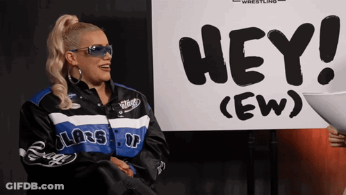 Woman Standing In Front Of Sign Saying Hey GIF