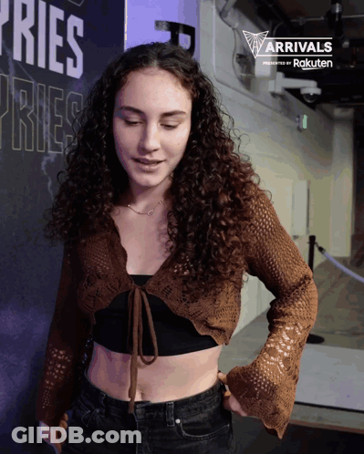 Woman Standing In Front Of Sign Saying Ries Ries GIF