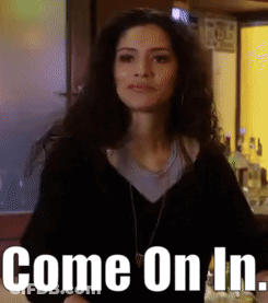 Woman Standing In Front Of Sign That Reads Come On In GIF