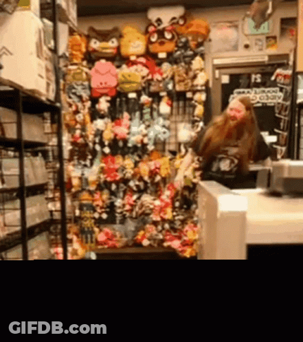 Woman Standing In Front Of Stuffed Animals GIF