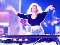 Woman Standing In Front Of Table With Arms In The Air GIF