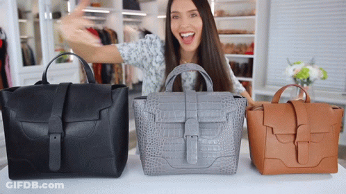 Woman Standing In Front Of Table With Three Bags GIF