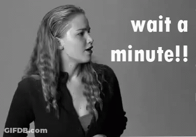 Woman Standing In Front Of Wait A Minute Sign GIF