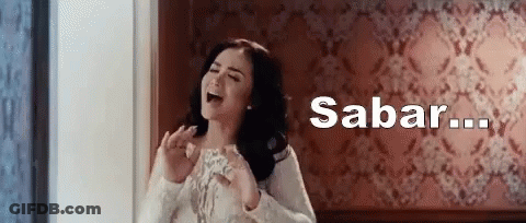 Woman Standing In Front Of Wall With Sabar Written Above GIF