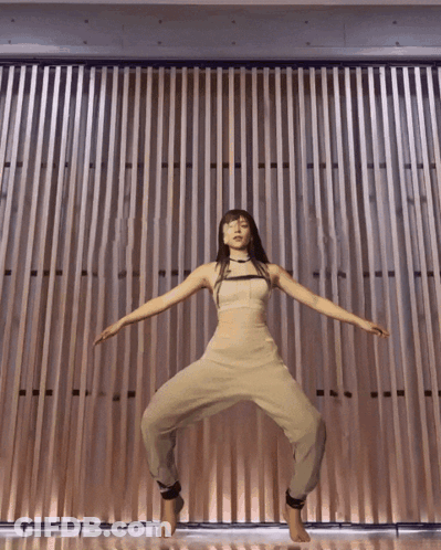 Woman Standing In Front Of Wooden Wall GIF