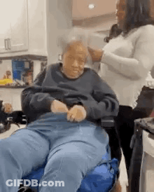 Woman Standing Next To Elderly Man In Wheelchair GIF
