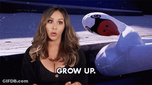 Woman Standing Next To Inflatable Flamingo Saying Grow Up GIF