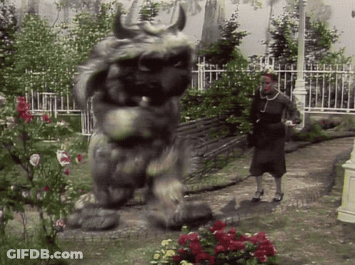 Woman Standing Next To Monster Statue GIF