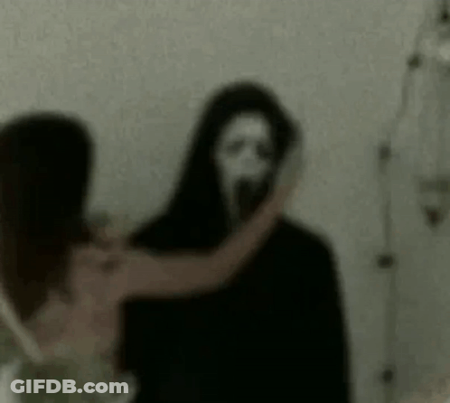 Woman Standing Next To Scary Ghost With Mask GIF