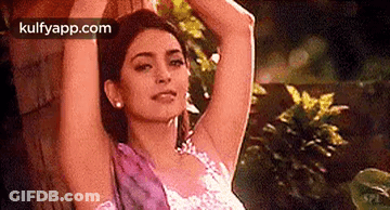 Woman Standing Next To Tree With Arms Outstretched GIF