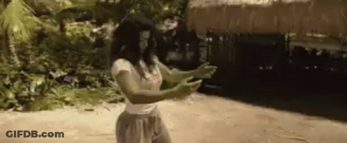 Woman Standing On Beach In Front Of Hut GIF