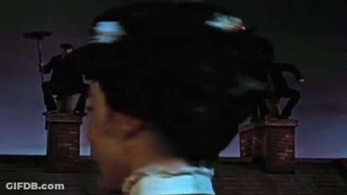 Woman Standing On Chimney With Broom In Hair GIF
