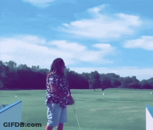 Woman Standing On Golf Course With Golf Club GIF