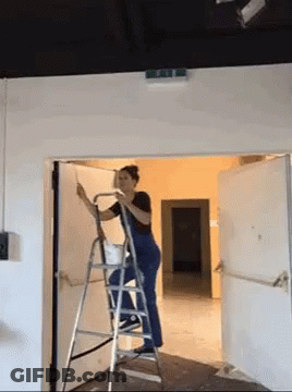 Woman Standing On Ladder In Front Of Door GIF