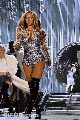 Woman Standing On Stage In Jumpsuit And Boots GIF