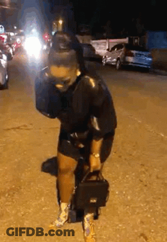 Woman Standing On Street Holding Purse GIF