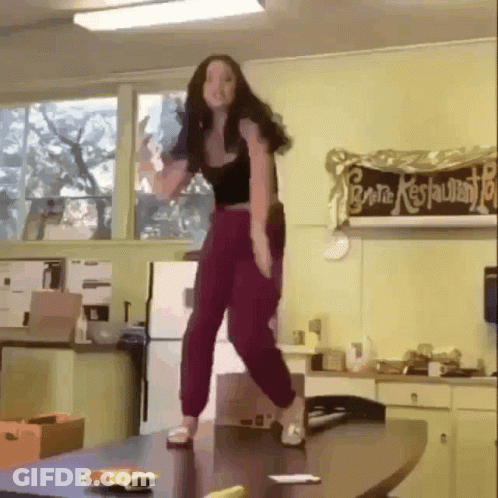 Woman Standing On Table In Front Of General Restaurant Sign GIF