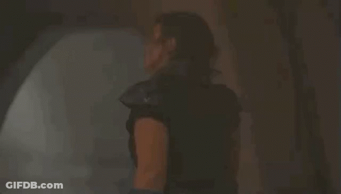 Woman Standing With Sword In Dark Room GIF