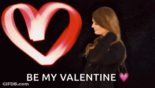 Woman Stands In Front Of Heart That Says Be My Valentine GIF