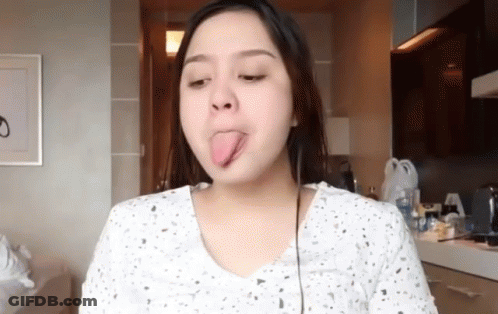 Woman Sticking Tongue Out In Kitchen GIF