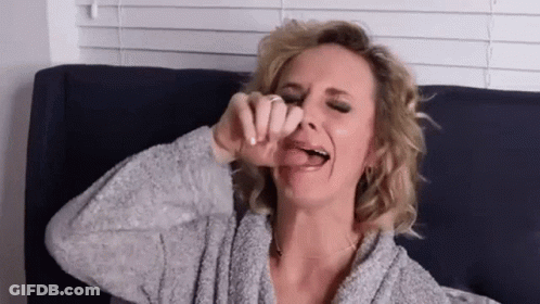 Woman Sticking Tongue Out On Couch GIF