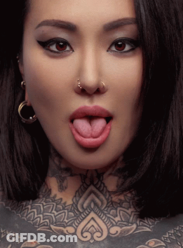 Woman Sticking Tongue Out With Nose Ring And Chest Tattoo GIF