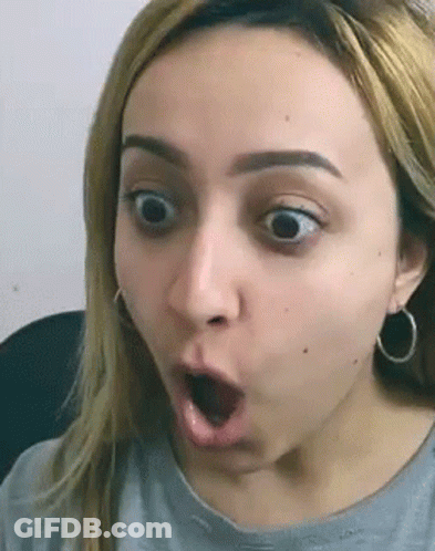 Woman Surprised Wearing Earrings And Gray Shirt GIF