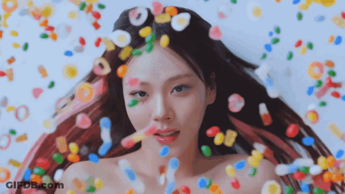 Woman Surrounded By Colorful Candies And Candy Drops GIF