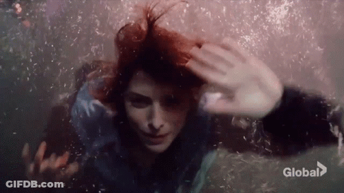 Woman Swimming Underwater Eyes Closed Bubbles From Hair GIF