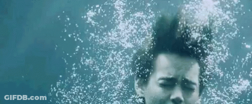 Woman Swimming Underwater Eyes Closed Bubbles From Hair GIF