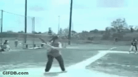 Woman Swinging Bat At Baseball On Field GIF