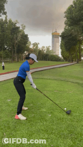 Woman Swinging Golf Club At Ball GIF