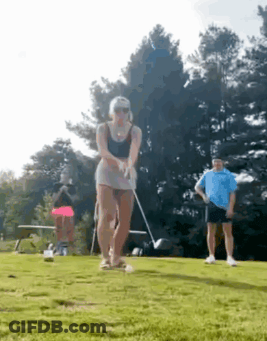 Woman Swinging Golf Club On Course GIF