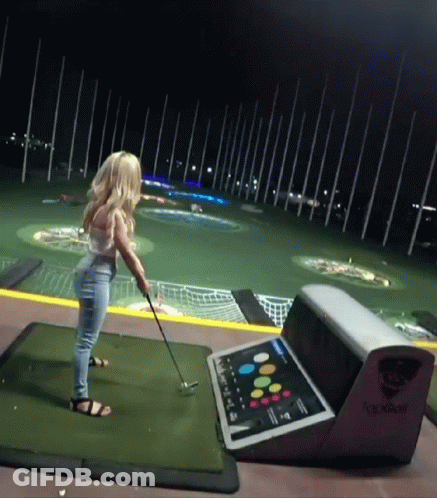 Woman Swinging Golf Club On Golf Course At Night GIF