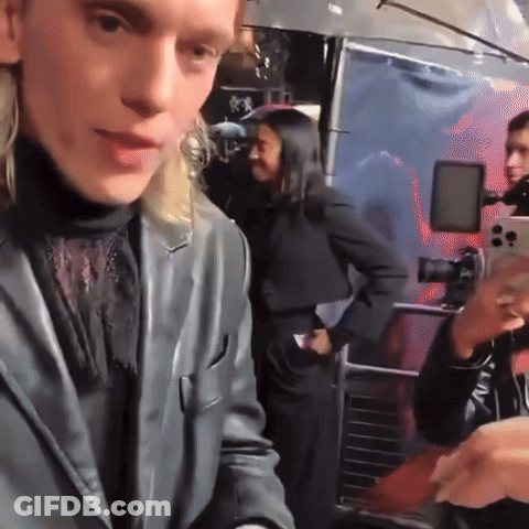 Woman Taking Picture Of Man In Black Suit GIF
