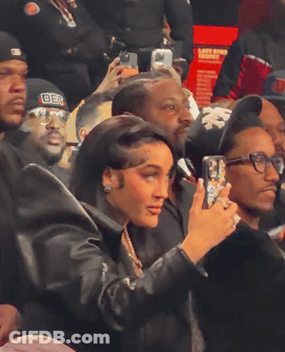 Woman Taking Picture Of Man In DST Hat GIF