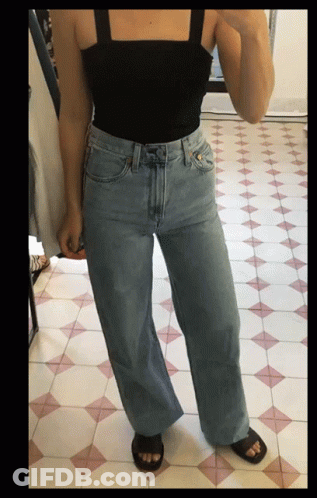 Woman Taking Selfie In Black Tank Top And Wide Leg Jeans GIF