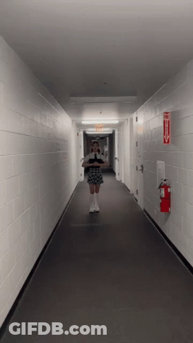 Woman Taking Selfie In Hallway With Fire Extinguisher GIF
