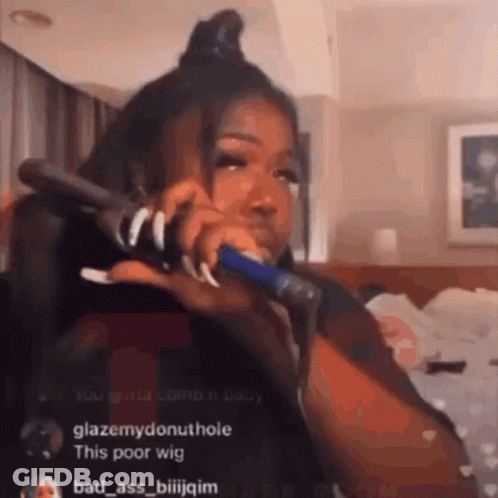 Woman Talking Into Hair Straightener GIF