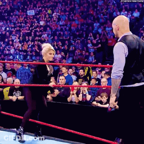 Woman Talking To Bald Man In Wrestling Ring GIF