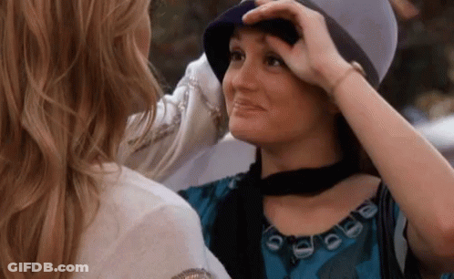Woman Touching Another Woman's Hat GIF