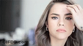 Woman Touching Forehead Looking At Camera GIF